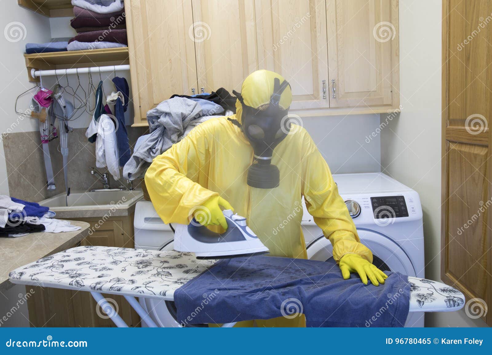 mature woman in haz mat suit ironing shirt on board with steam