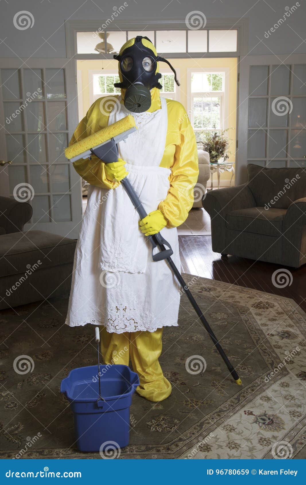 mature woman in haz mat suit in living room with mop