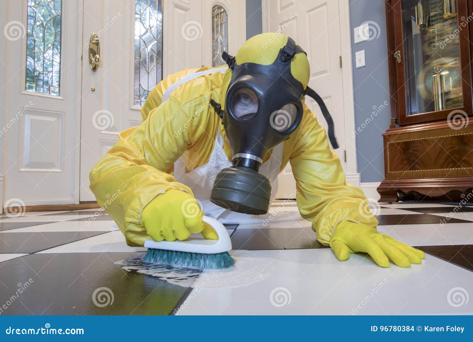 mature woman in haz mat suit scrubbing floor with brush