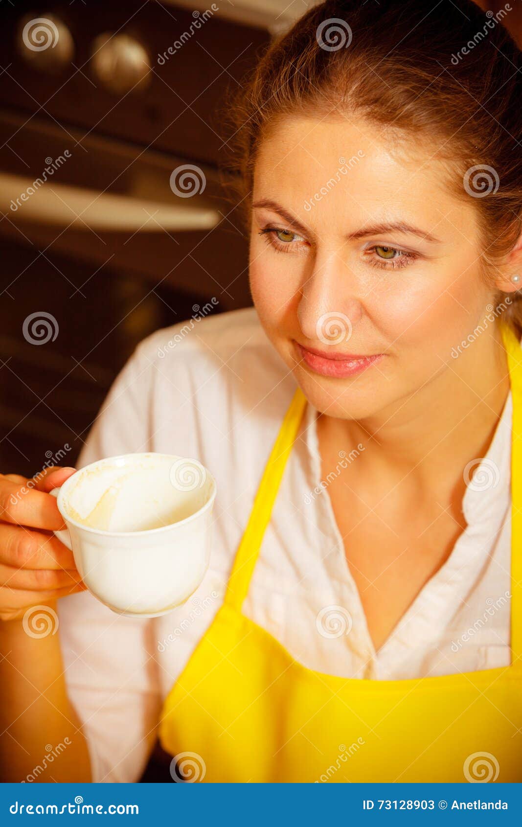 Mature Woman Holding Cup Of Coffee In Kitch