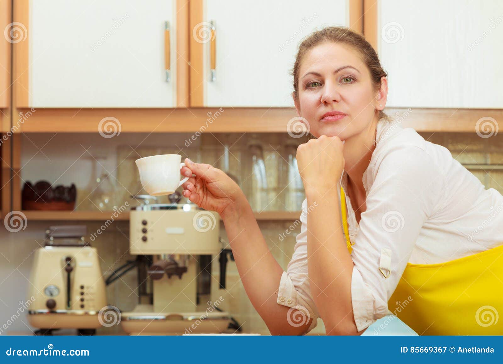 Mature Woman Holding Cup Of Coffee In Kitchen Stock Image I