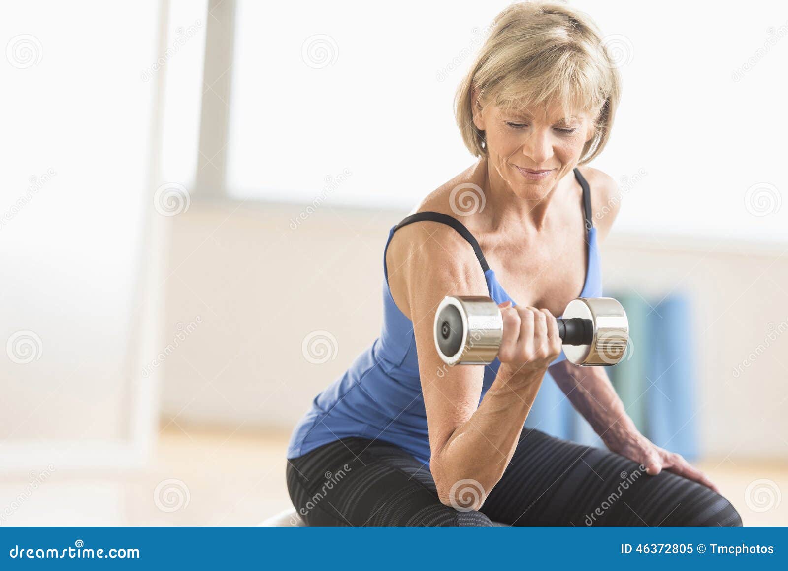 mature woman lifting dumbbell at home
