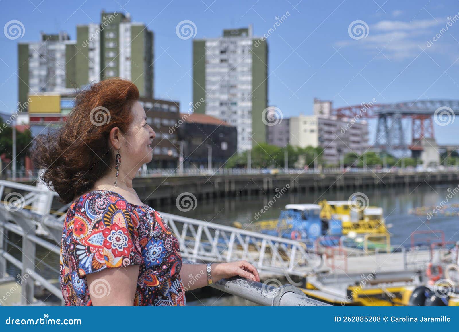 mature woman looking towards the riachuelo, in la boca, buenos aires, argentina
