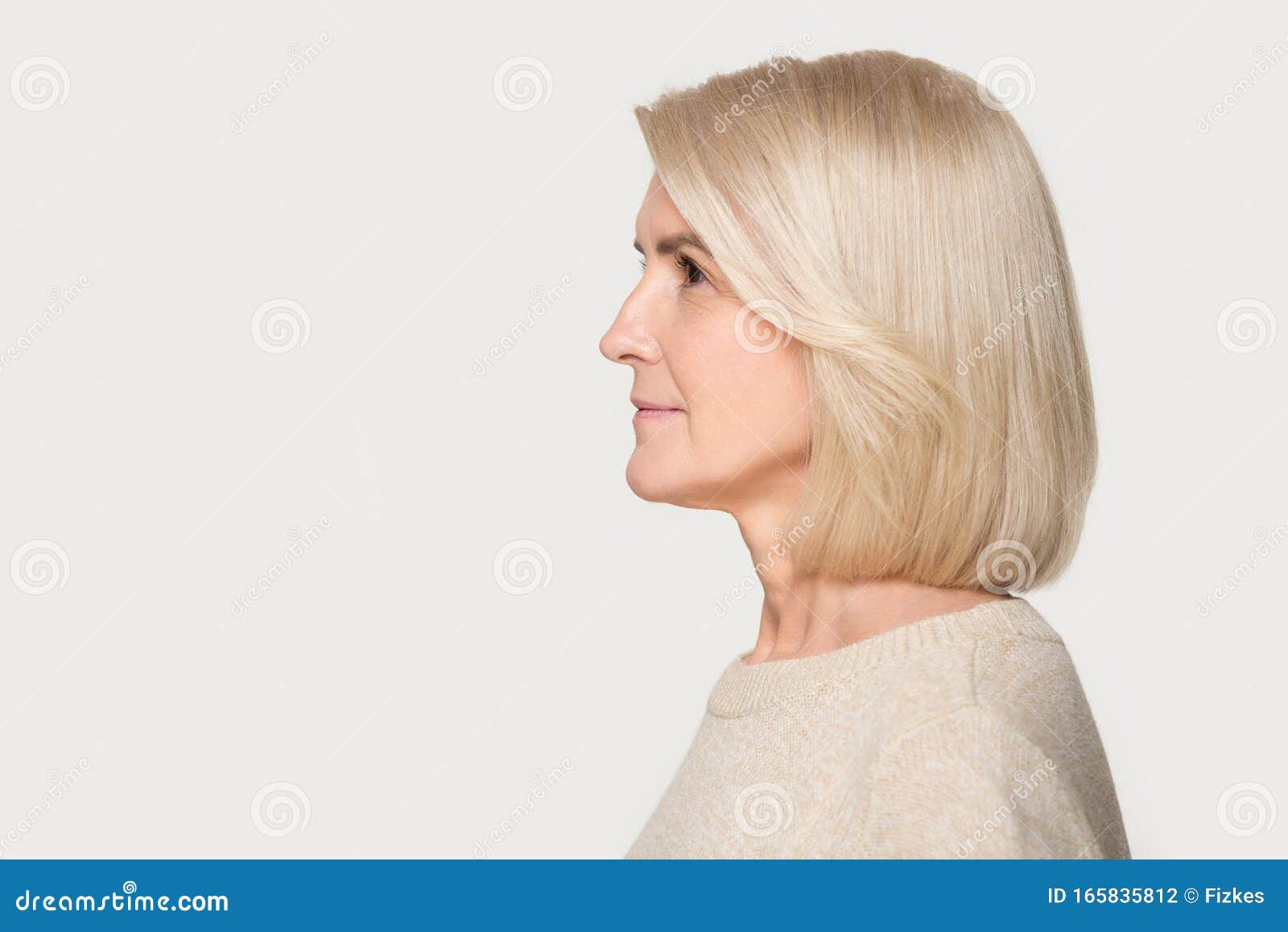 mature woman profile view studio portrait  on gray background