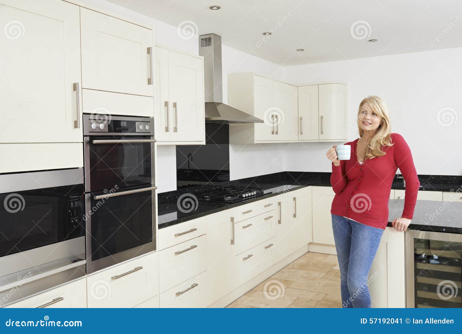 Mature Woman Standing In New Luxury Fitted Kitchen Stock Image Image