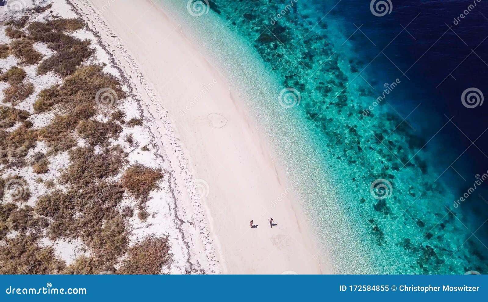 maumere - a drone shot of a couple playing on a white sand beach