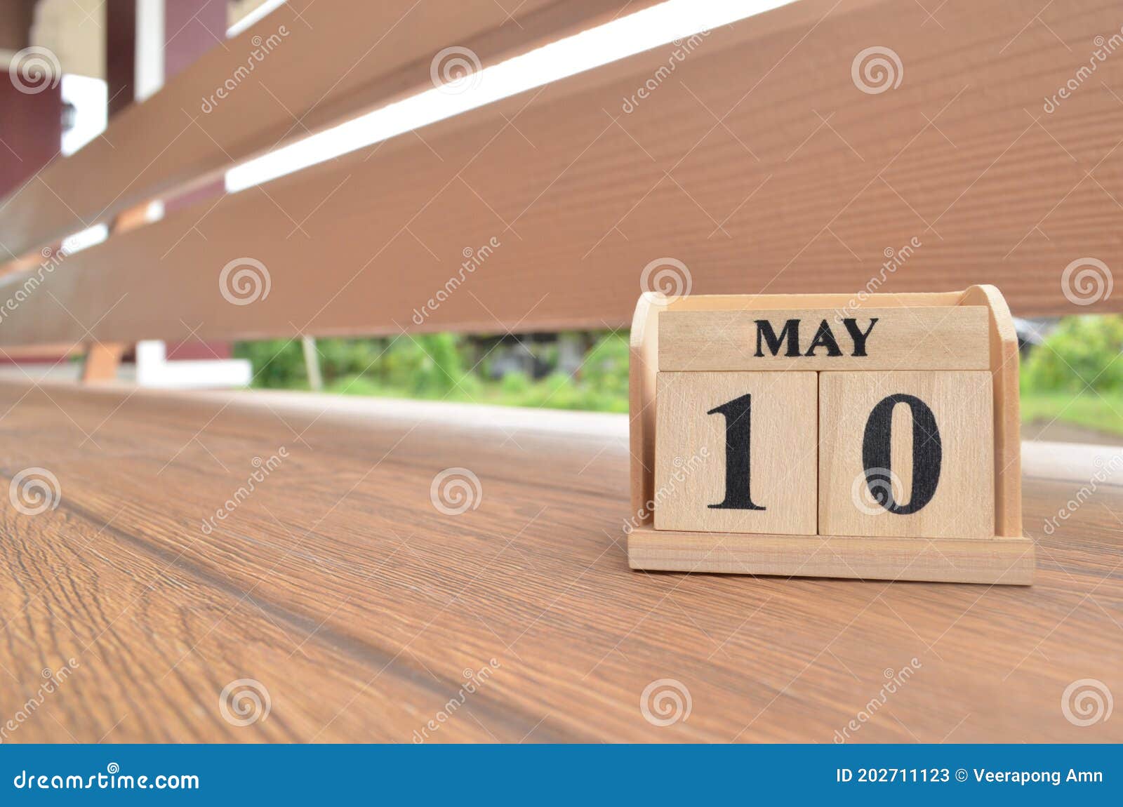 may 10, number cube with wooden balcony background.