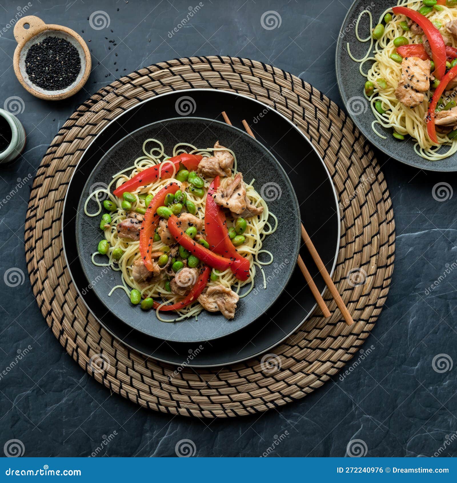 A Meal of Chicken Pieces with Edamame Beans, Red Peppers and Black
