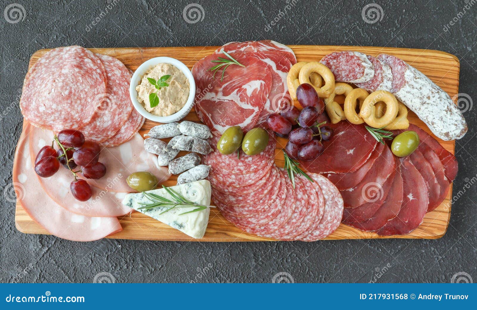 meat and cheese board with products from italy - prosciutto, mortadella, felino, bresaola, gorgonzola, parmesan, pate, green