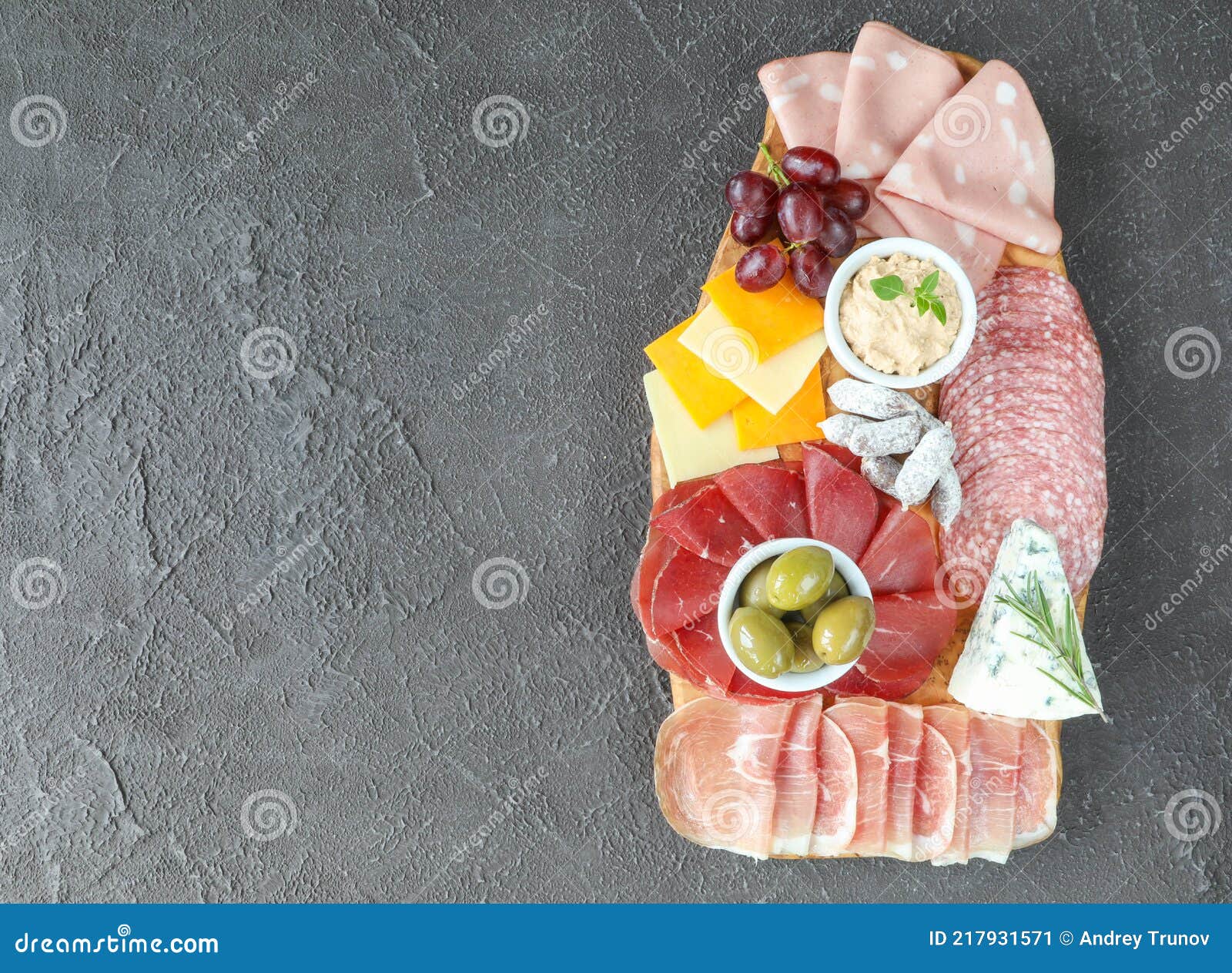 meat and cheese board with products from italy - prosciutto, mortadella, felino, bresaola, gorgonzola, parmesan, pate, green