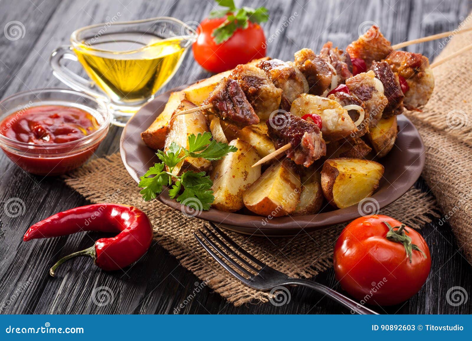 Meat Skewer with Herbs with Onions, Baked Potatoes, Tomatoes and Greens ...