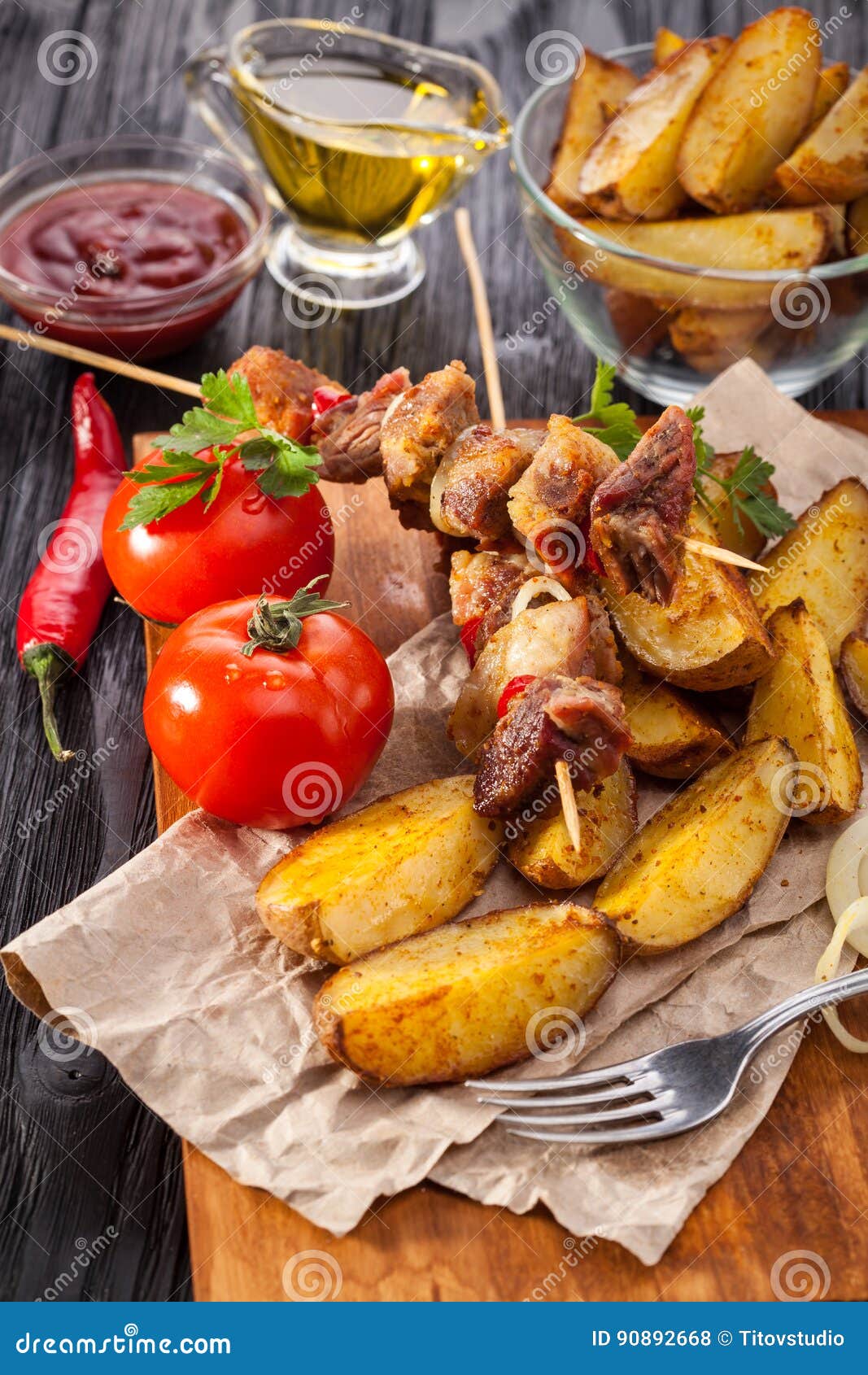 Meat Skewer with Herbs with Onions, Baked Potatoes, Tomatoes and Greens ...
