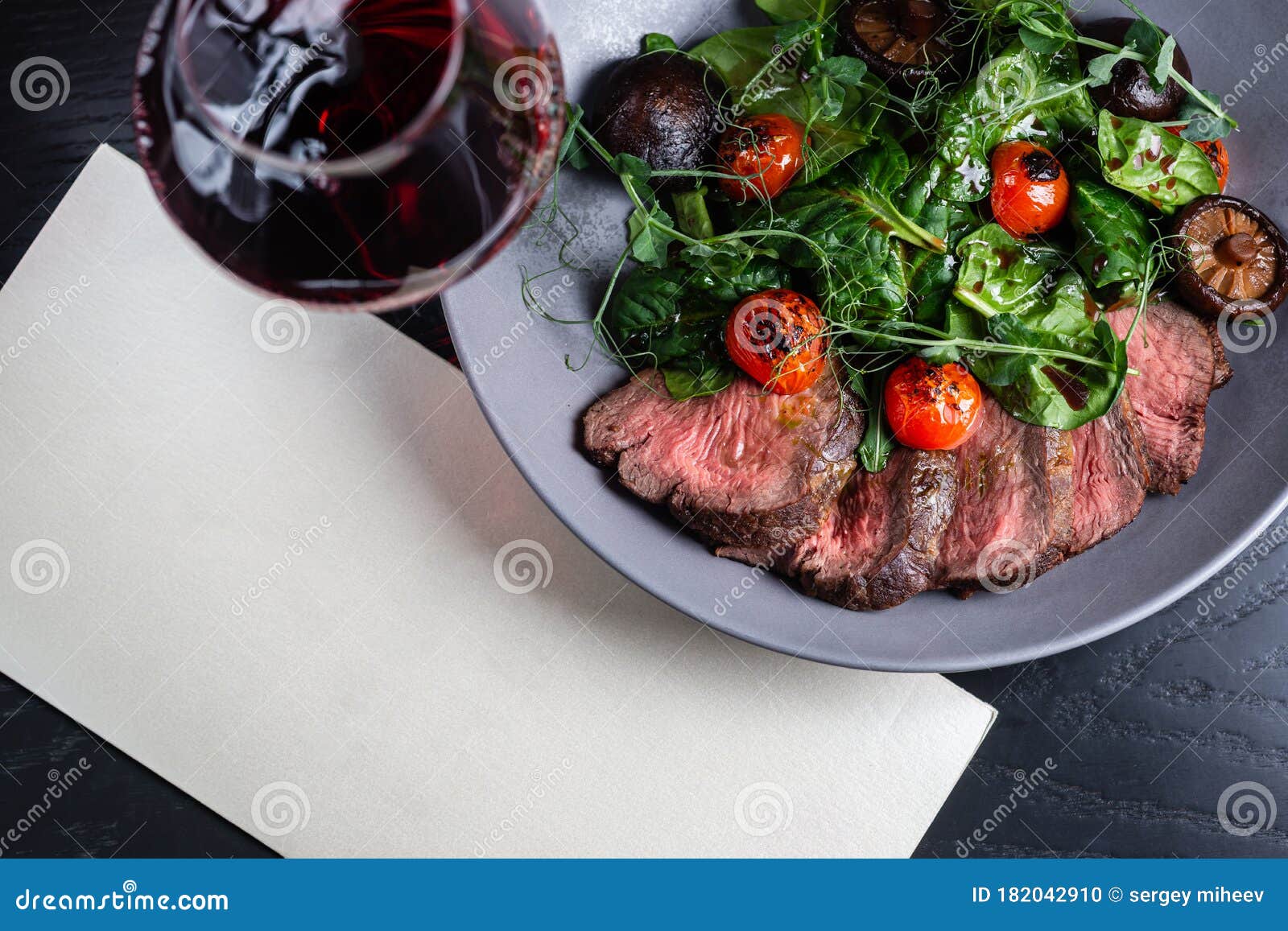 Meat with Wine on a Plate with Herbs and Tomatoes. Place for Text Stock