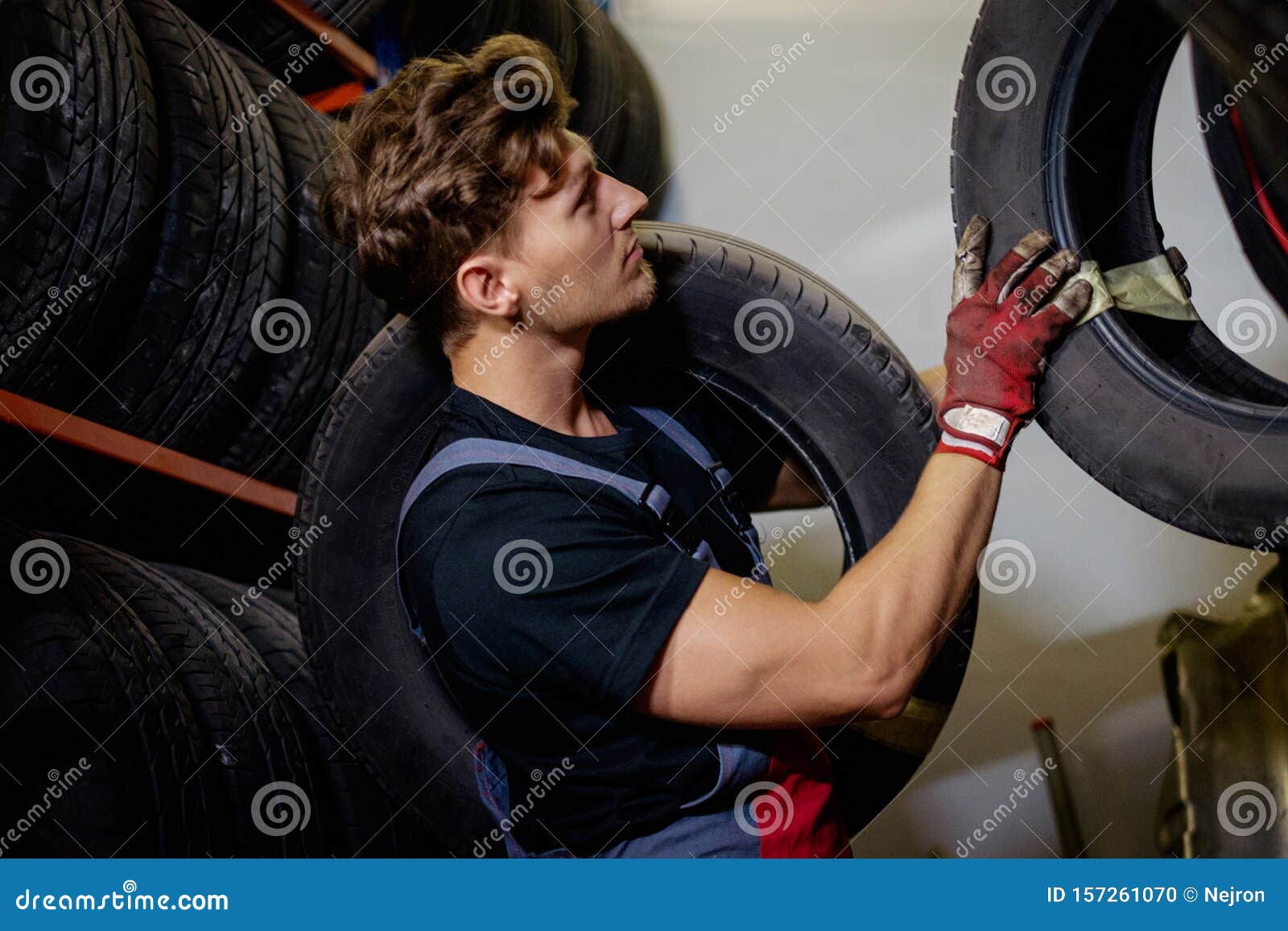 Mechanic Choosing Tires in a Warehouse Stock Photo Image of