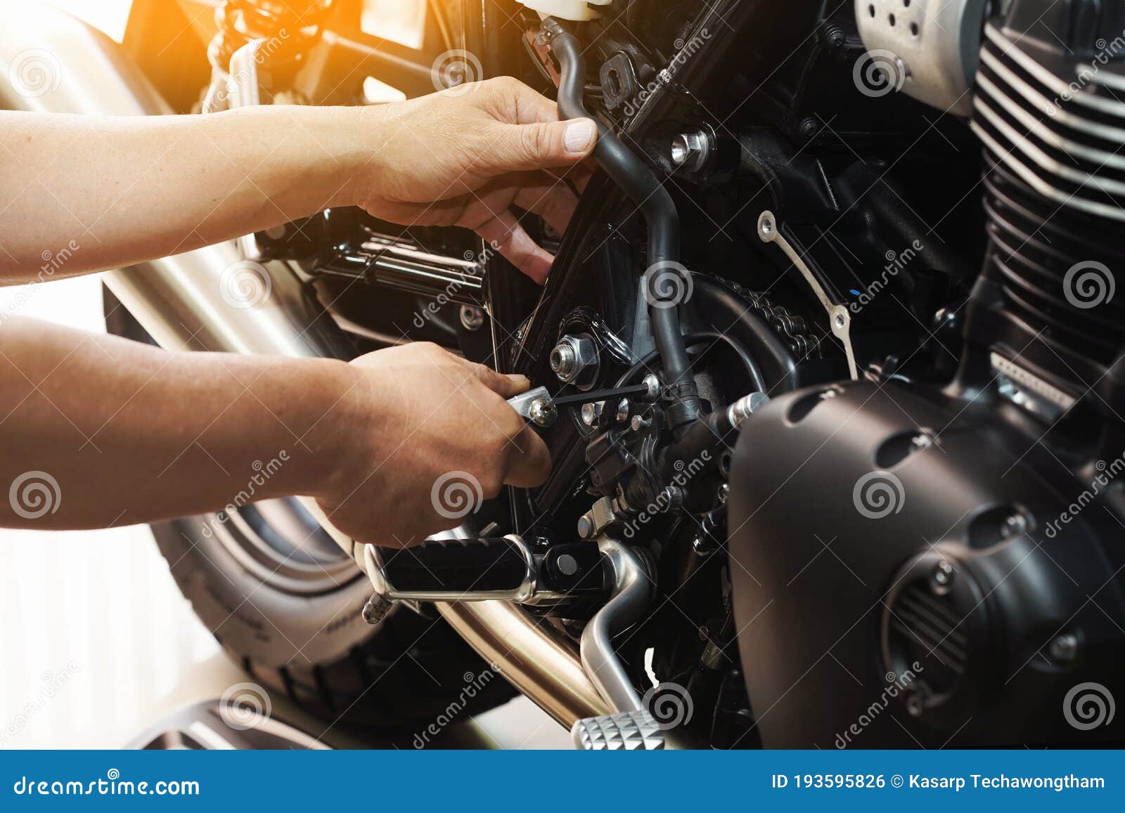 mechanic hold hex key wrench working on motorcycle at motorbike garage , concept of motorcycle maintenance and repair.selective