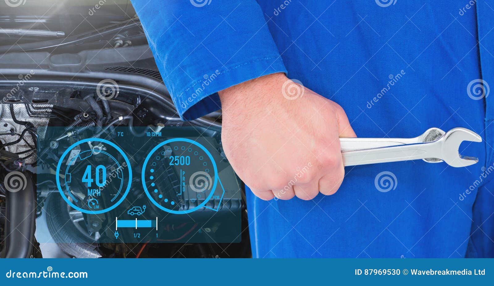 Mechanic Holding Wrenches Against Car Mechanics in Background Stock