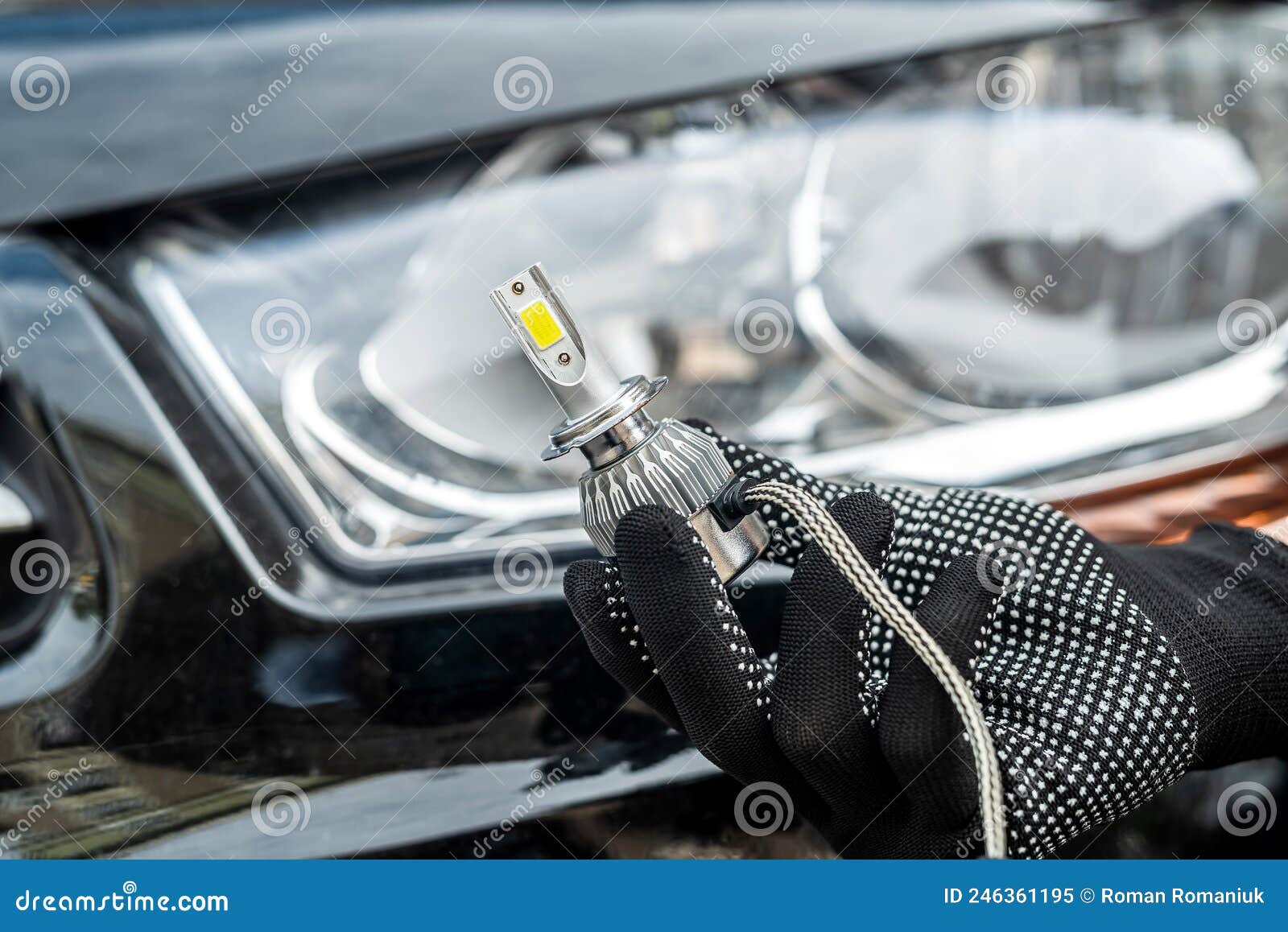 mechanic installing modern led h7 light bulb with wires in headlamp