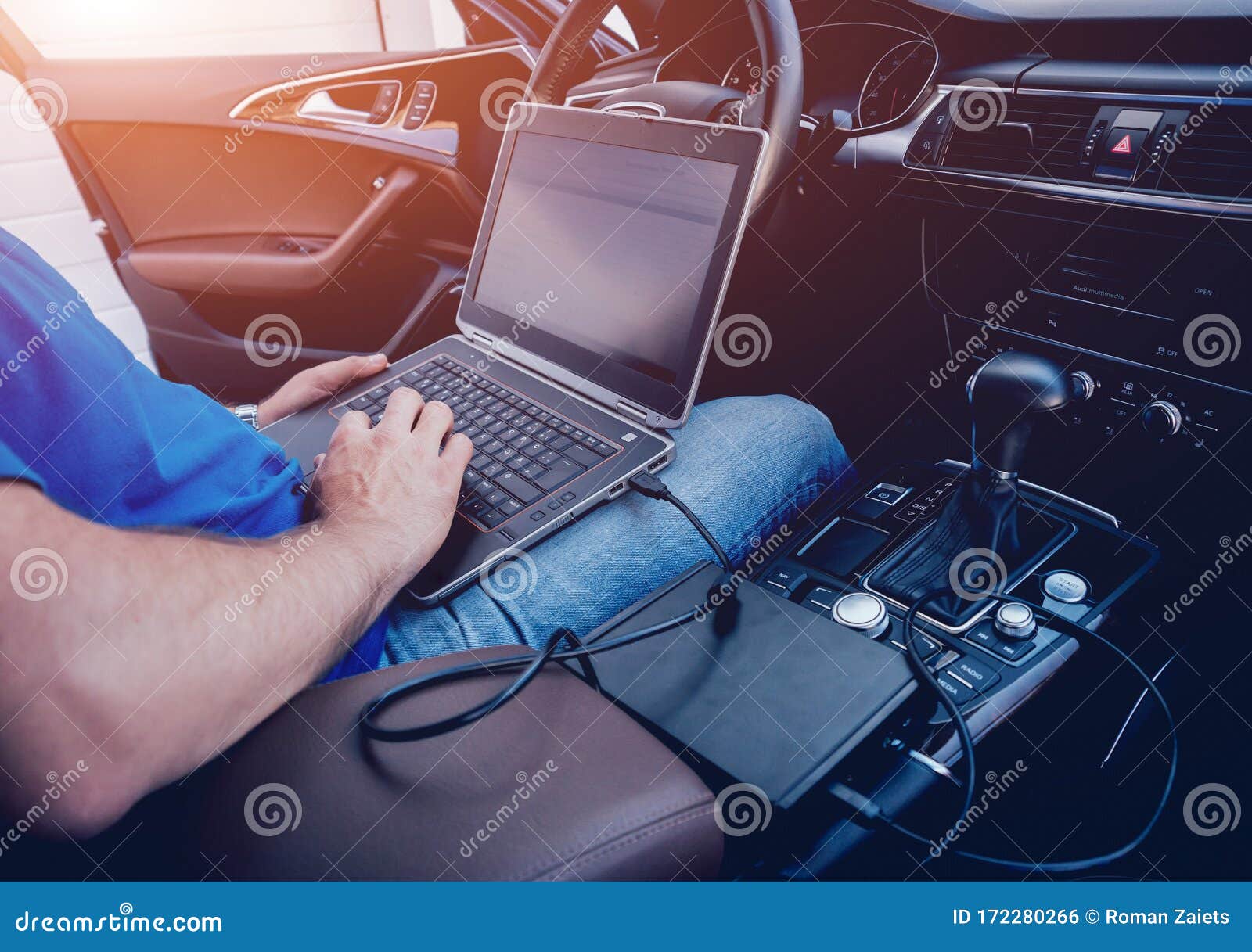 mechanic man with laptop making car diagnostics at auto service