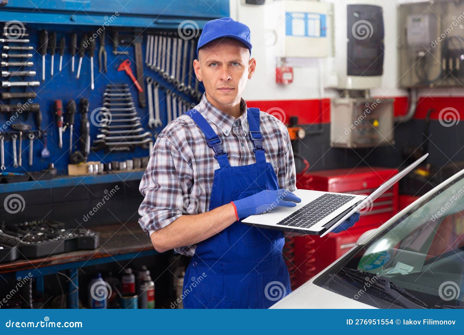 Mechanic Man with Laptop Making Car Diagnostics at Service Stock Photo