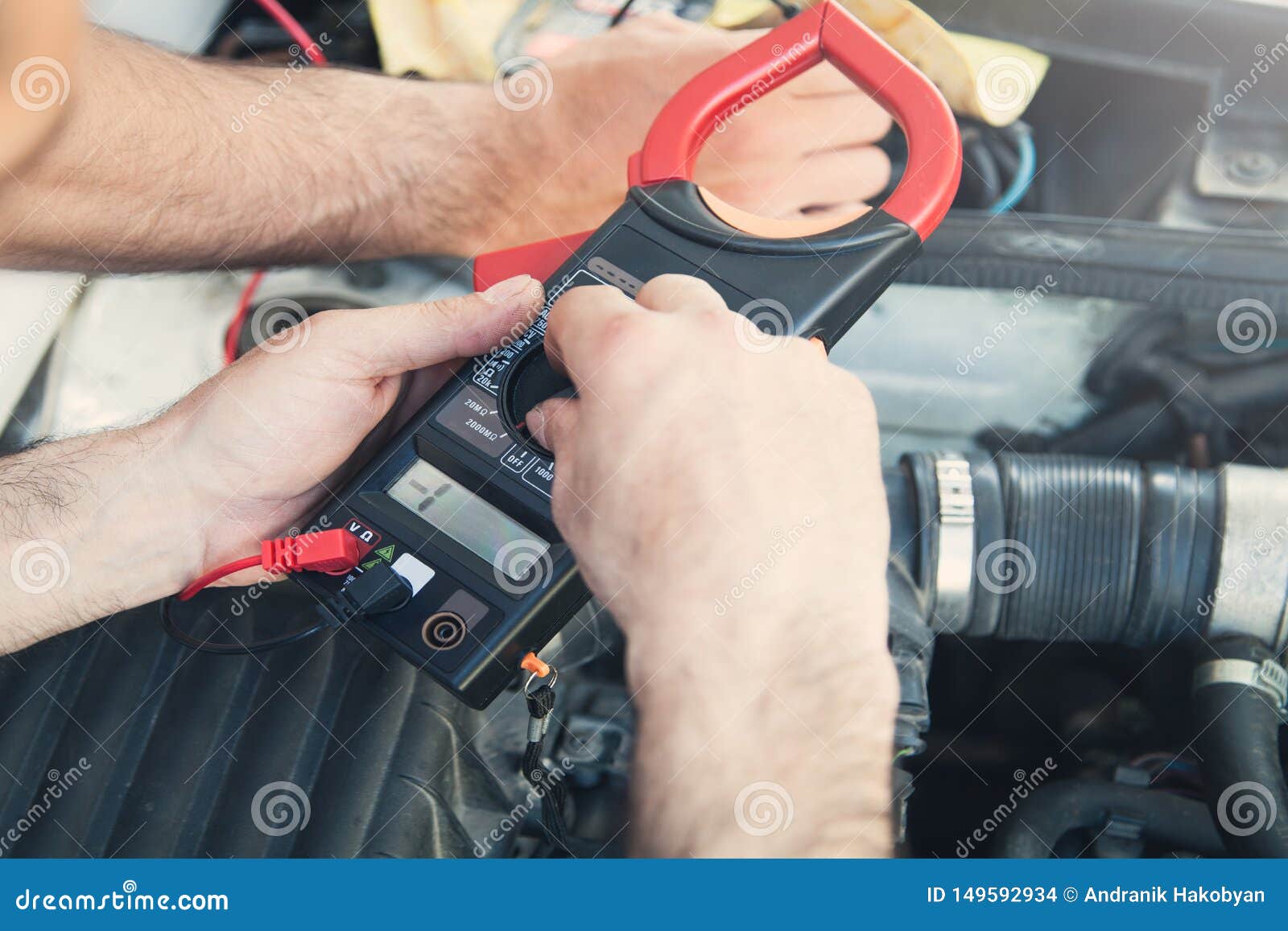 Mechanic with a Multimeter Testing Car Engine. Car Service Stock Photo