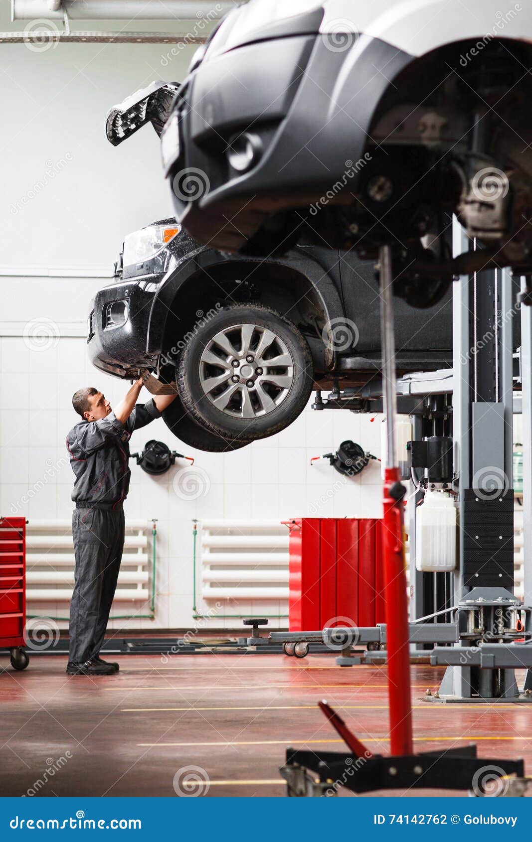 Mechanic Removing Engine Protection On Raised Car Stock Photo - Image