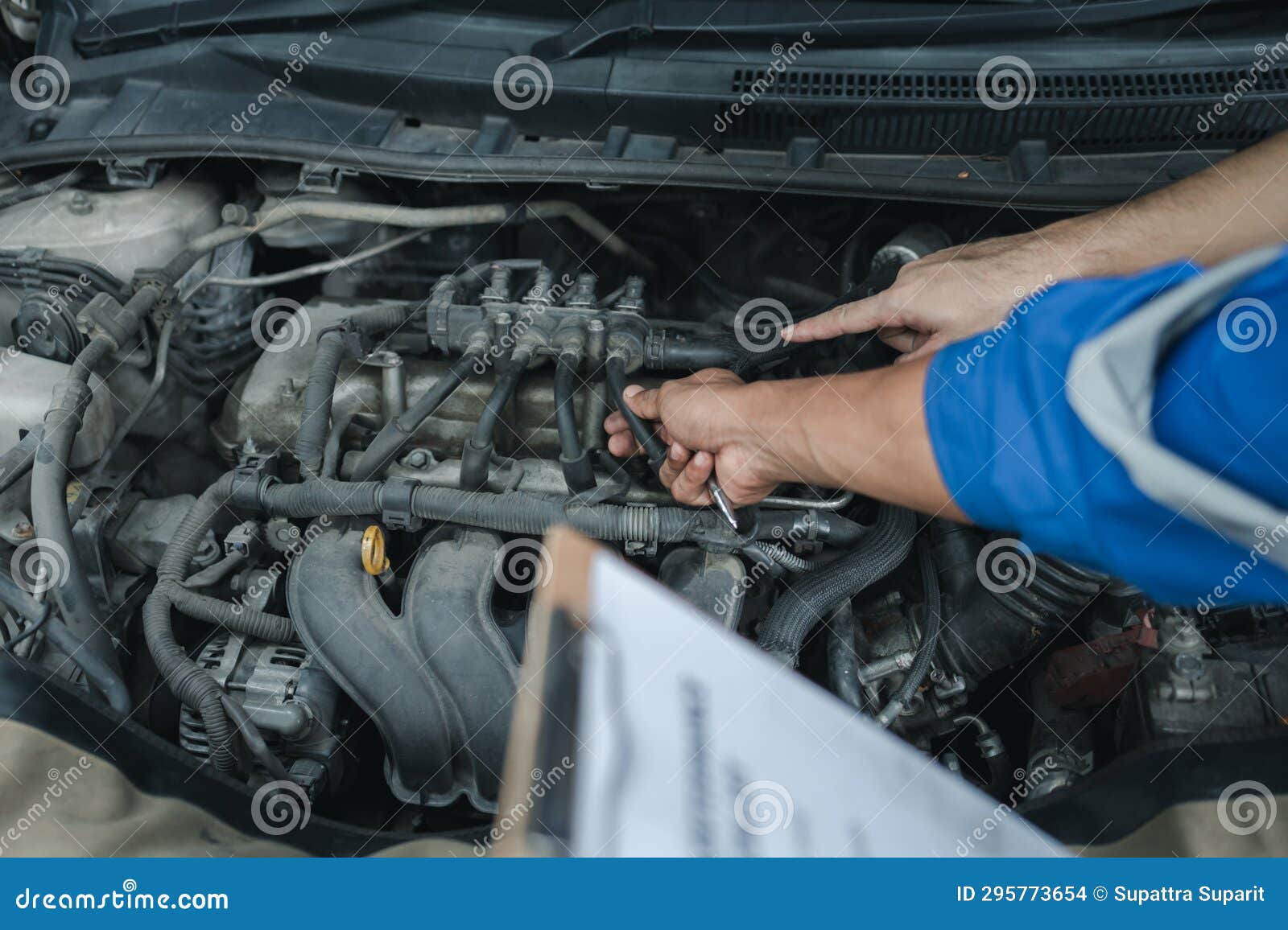 The Mechanic is Repairing the Engine, a Car Repair Worker is Inspecting