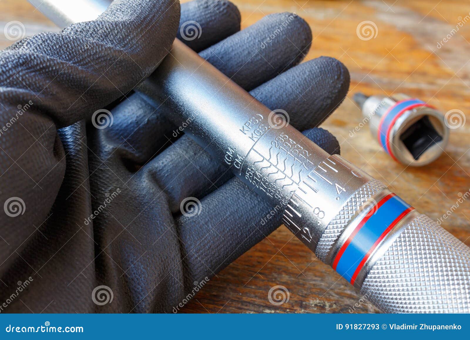 mechanic`s hand in the working glove holds the torque wrench