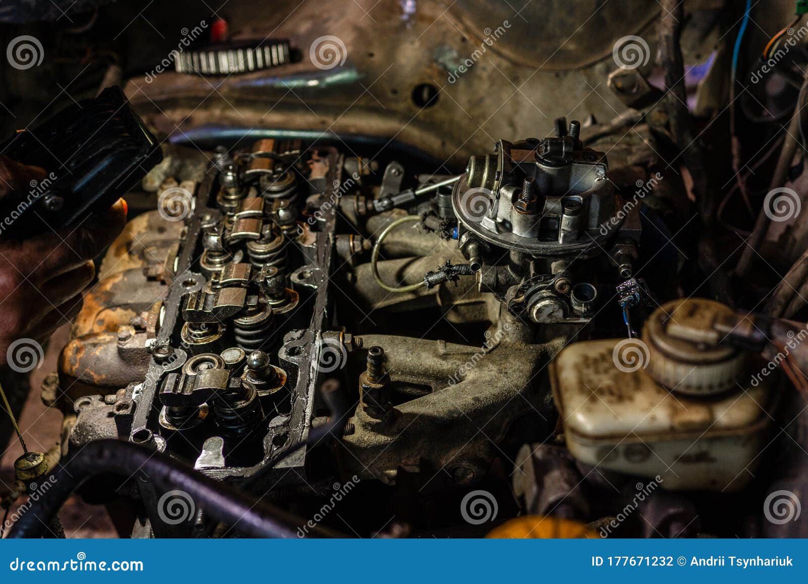 A Mechanic Shines a Flashlight on a Defective Engine in a Car Service