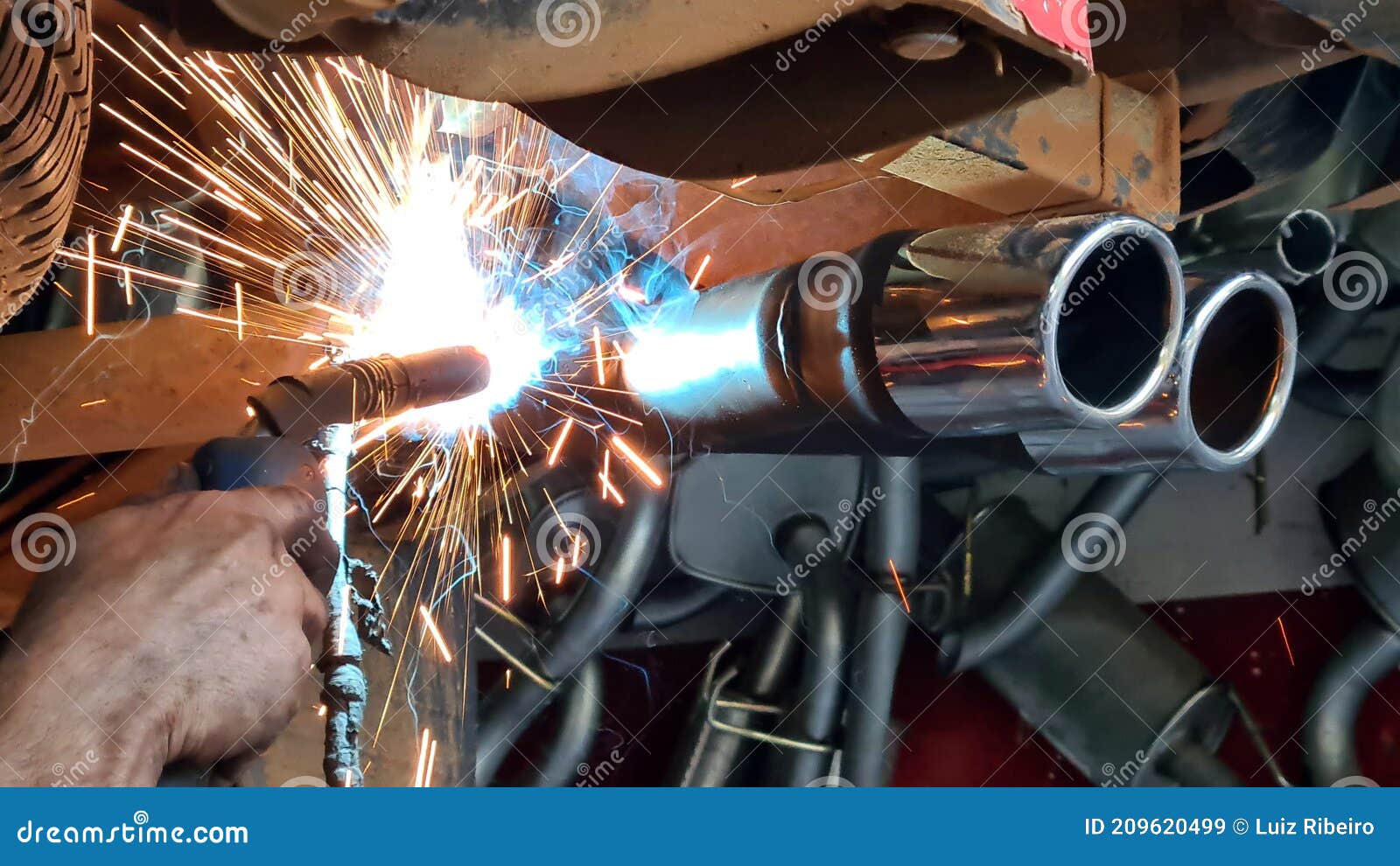 Mechanic or Welder is Fixing a Car Exhaust System by Welding the
