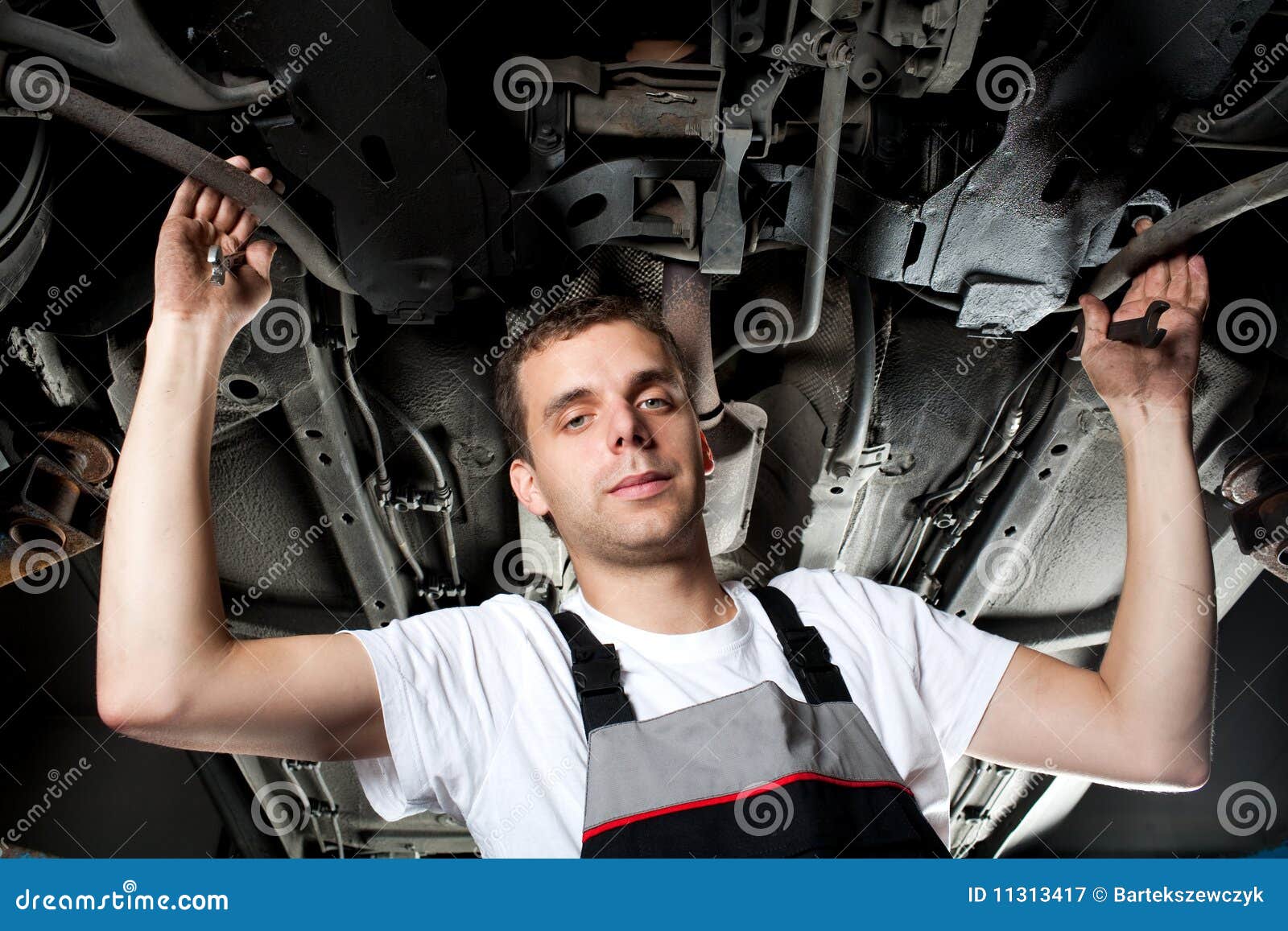 Mechanic Working Below Car in Uniform with Wrench Stock Image Image