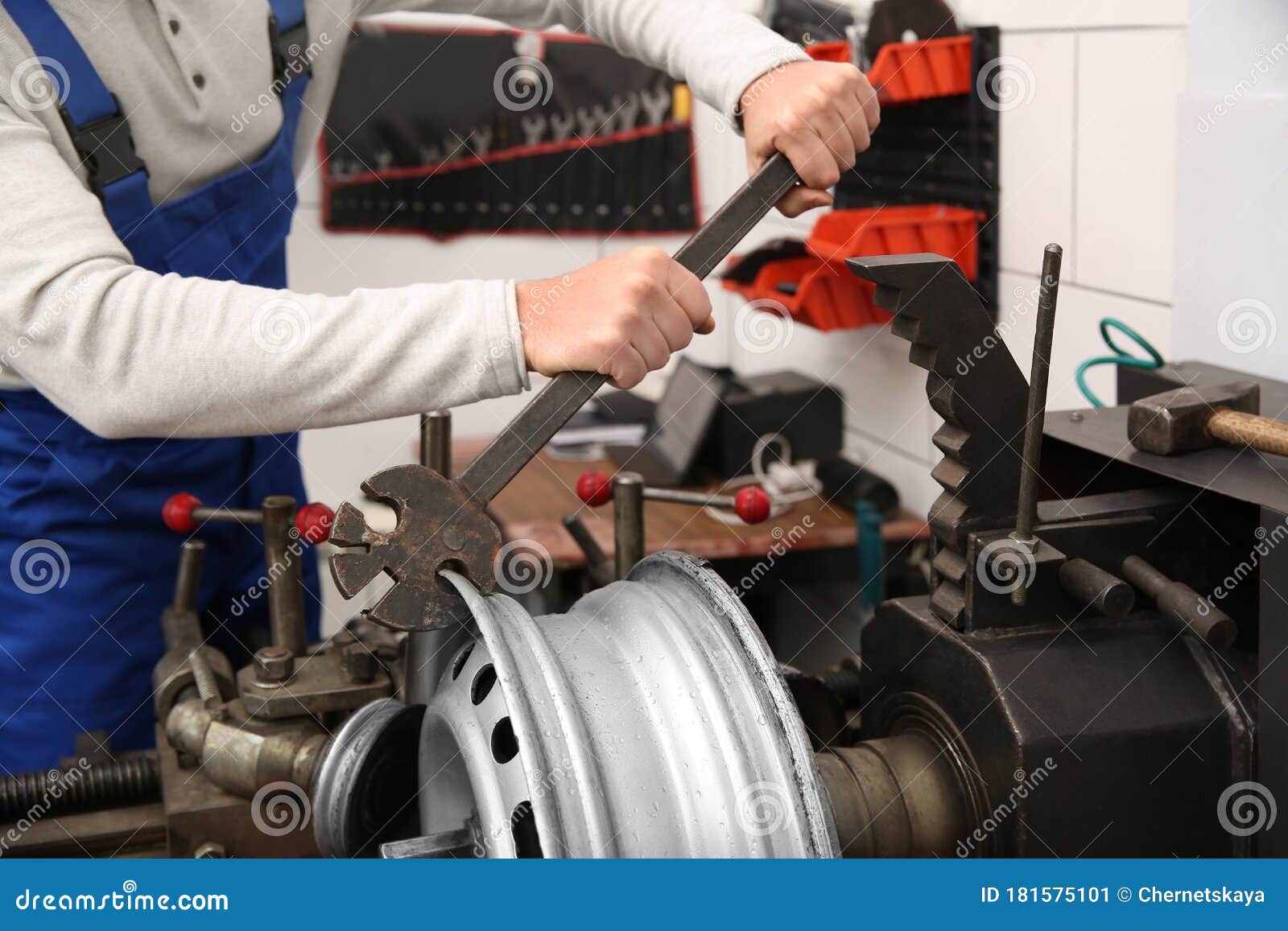 Mechanic Working with Car Disk Lathe Machine at Tire Service Stock