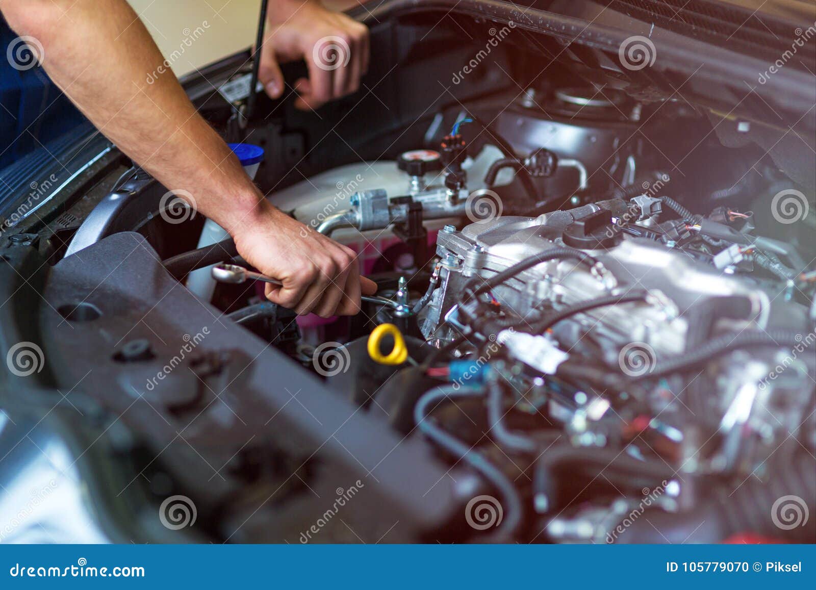 mechanic working on car engine in auto repair shop