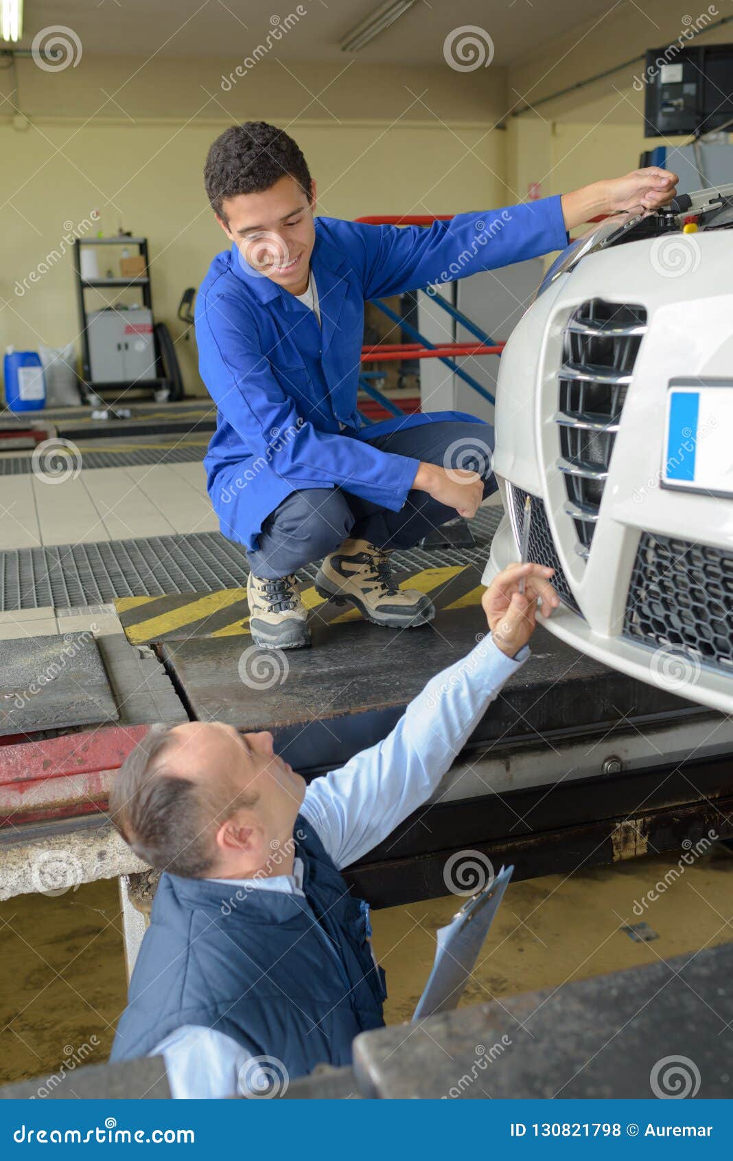 Mechanics Working on Wheel Underneath Car Stock Photo Image of service, maintenance 130821798