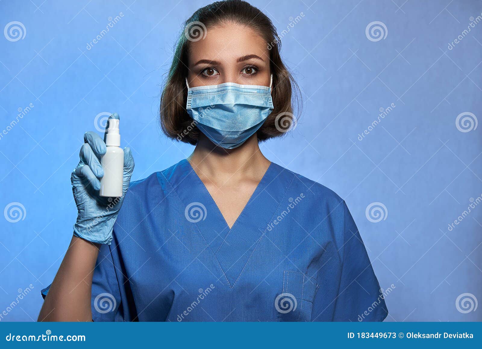 Medic in Protective Mask and Medical Gloves with Bottle of an ...