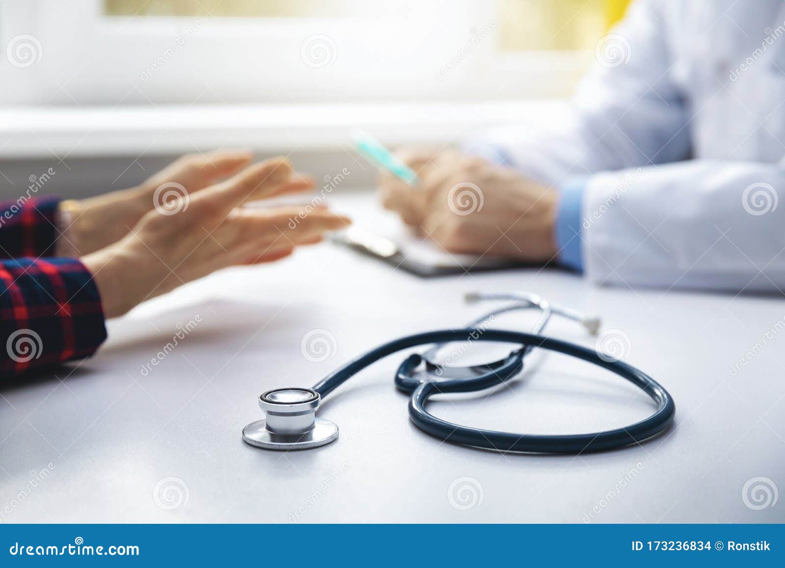 medical consultation - doctor talking to patient in clinic office