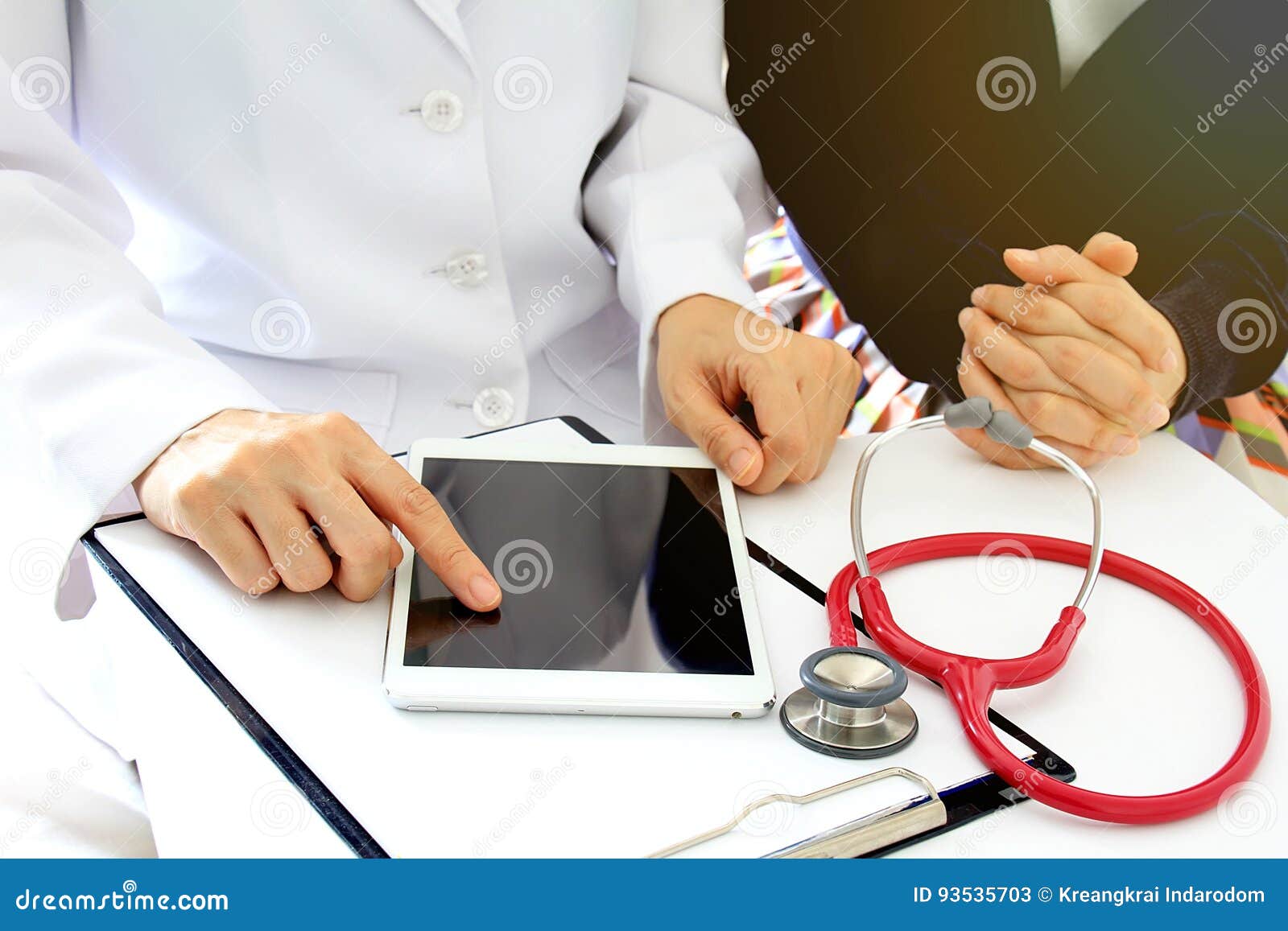 medical doctor discusses with patient about the health examination results by using tablet computer.