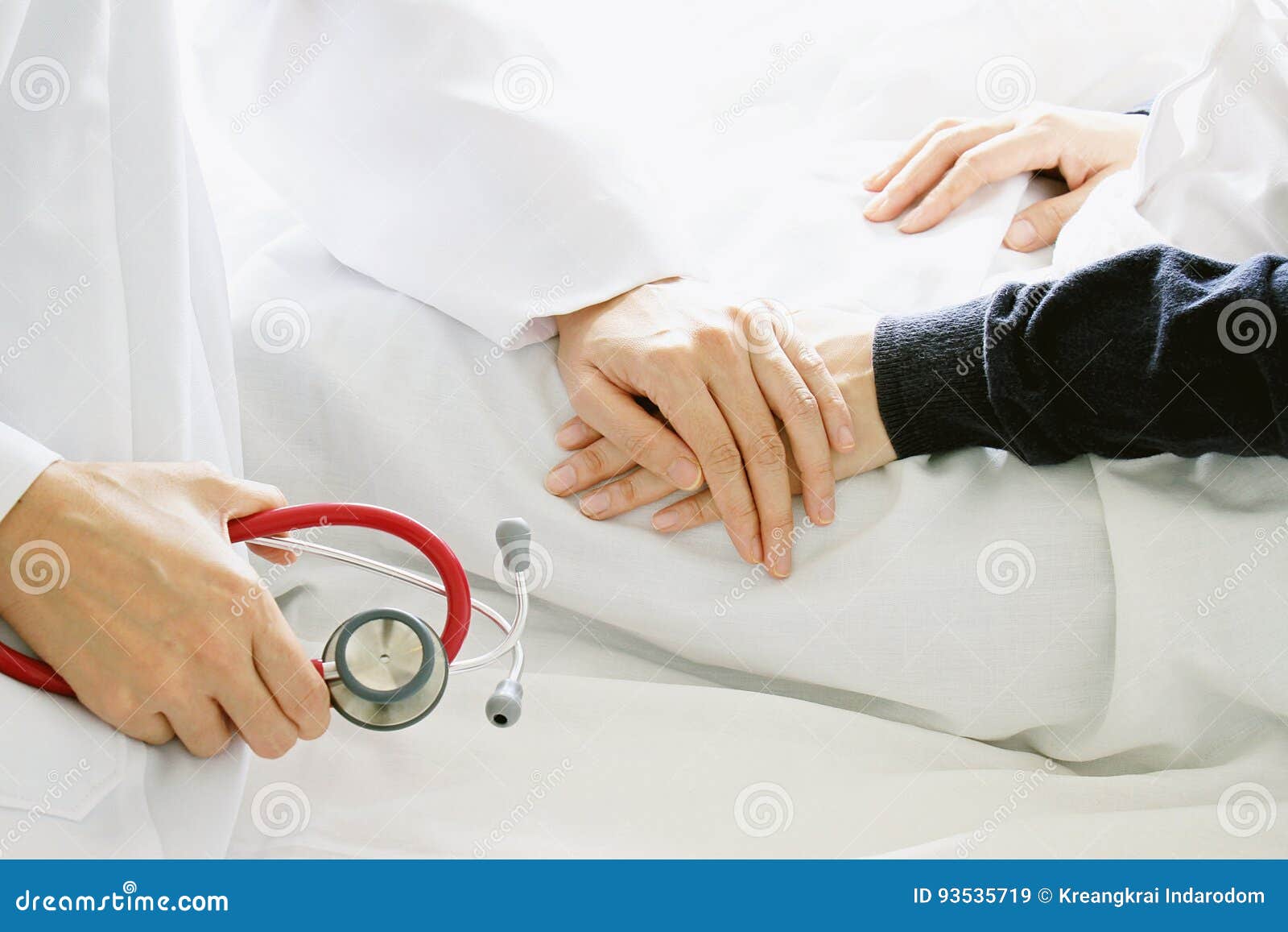 medical doctor holding patient`s hands and comforting her with care.