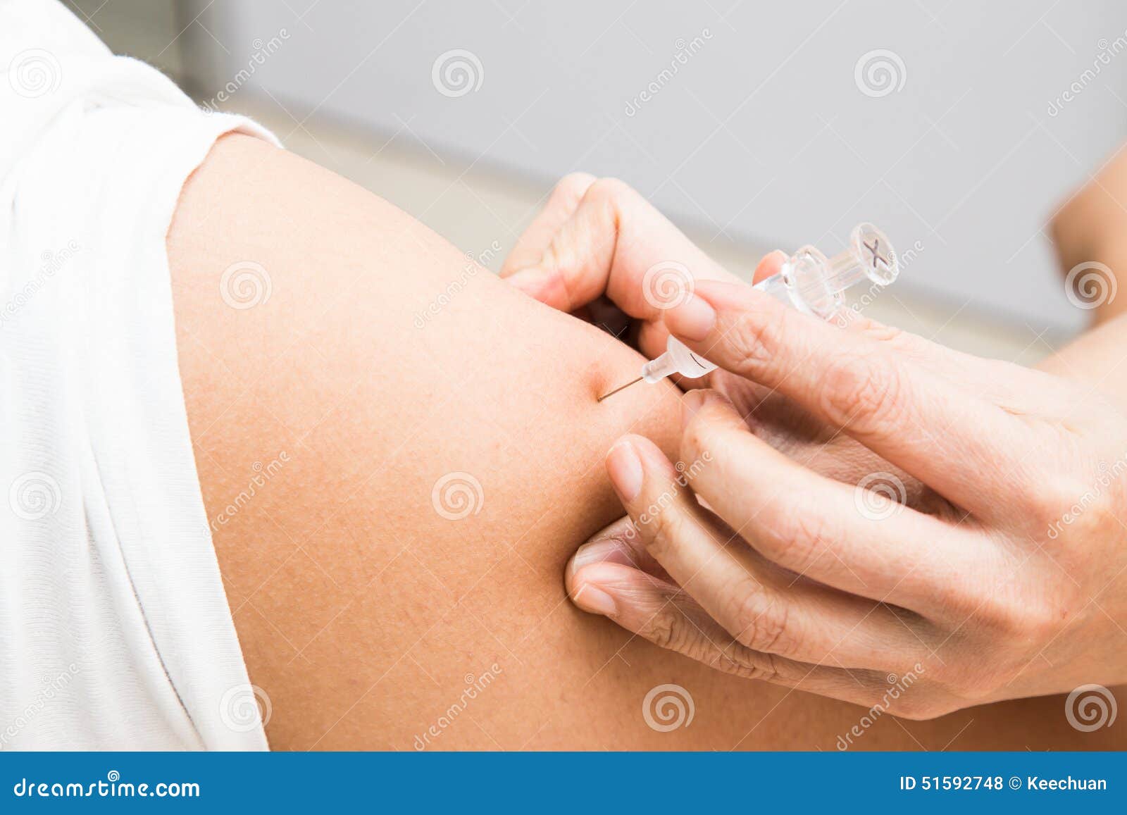 medical doctor preparing to inject vaccine into the arm of a patient