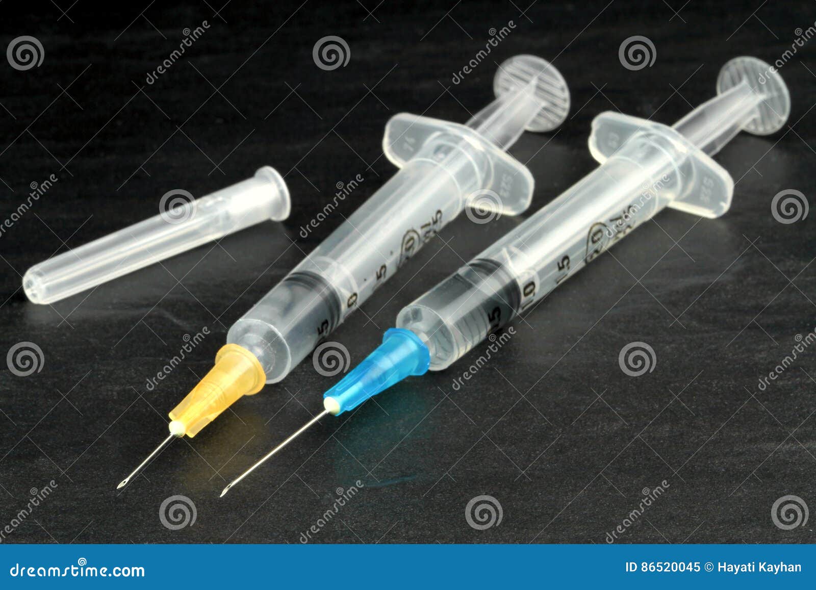 The Syringe with Long Needle and Medical Vial on Table. Black and