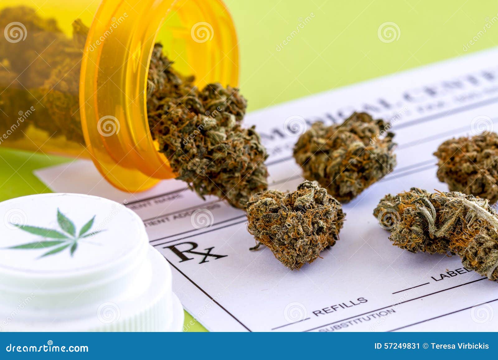 Medical Marijuana Buds and Seeds. Medical marijuana buds spilling out of prescription bottle with branded lid onto blank medical prescription pad on green background