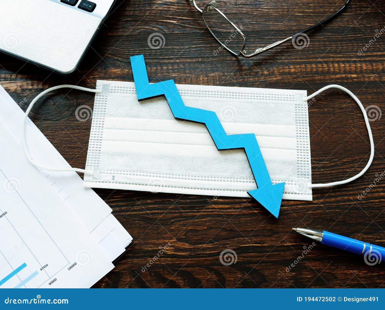 medical mask and down arrow as  of decrease of economy or number of cases per covid-19.