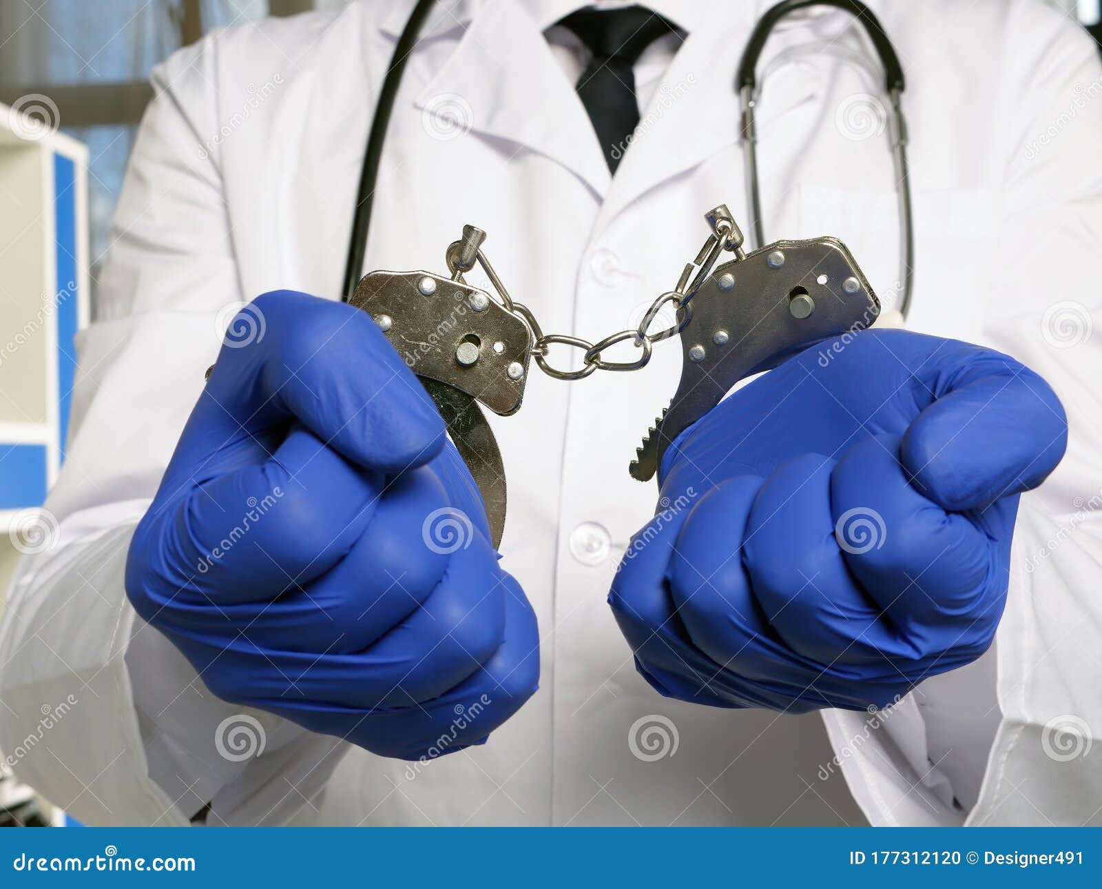 medical negligence or neglect. doctor stands in handcuffs