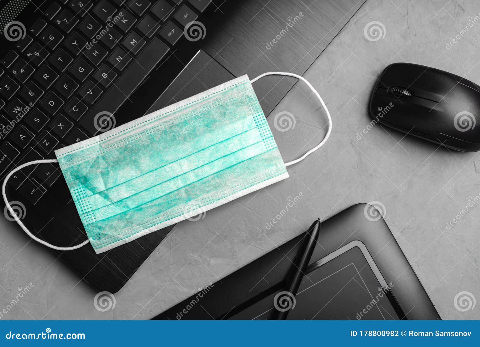 A Medical Personal Protective Mask is Placed Next To the Laptop and