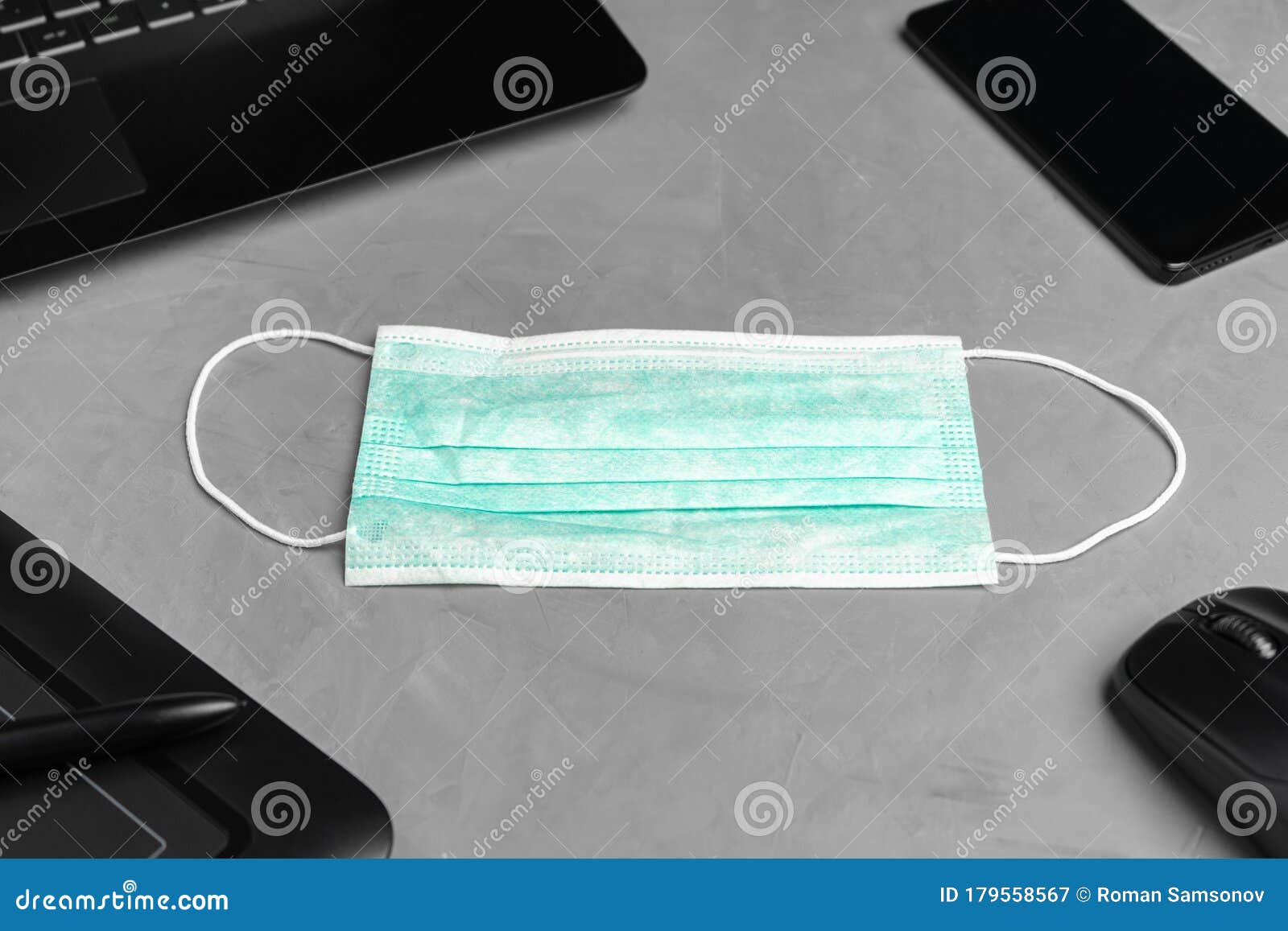 A Medical Personal Protective Mask is Placed Next To the Laptop and