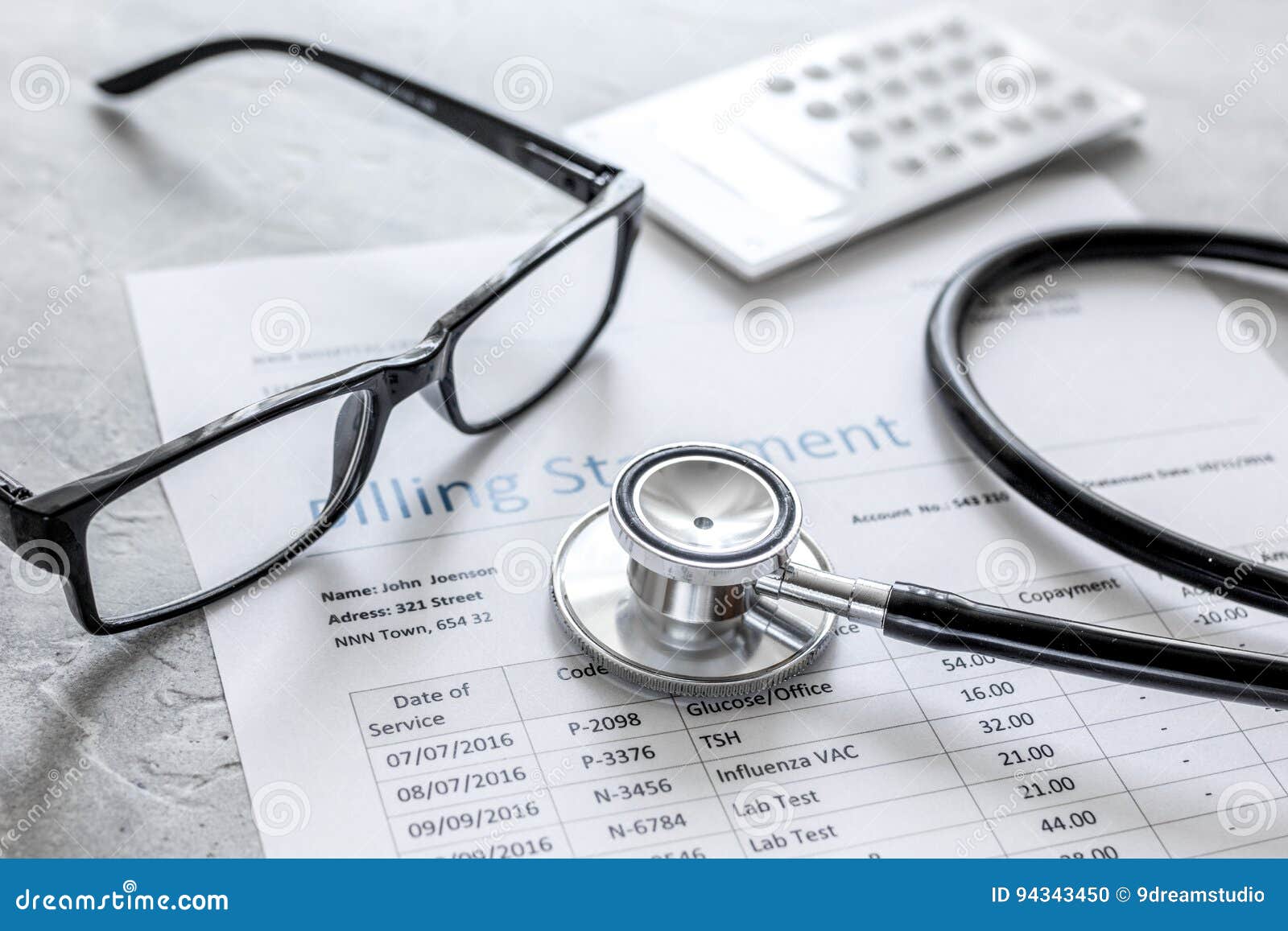medical treatmant billing statement with stethoscope and glasses on stone background