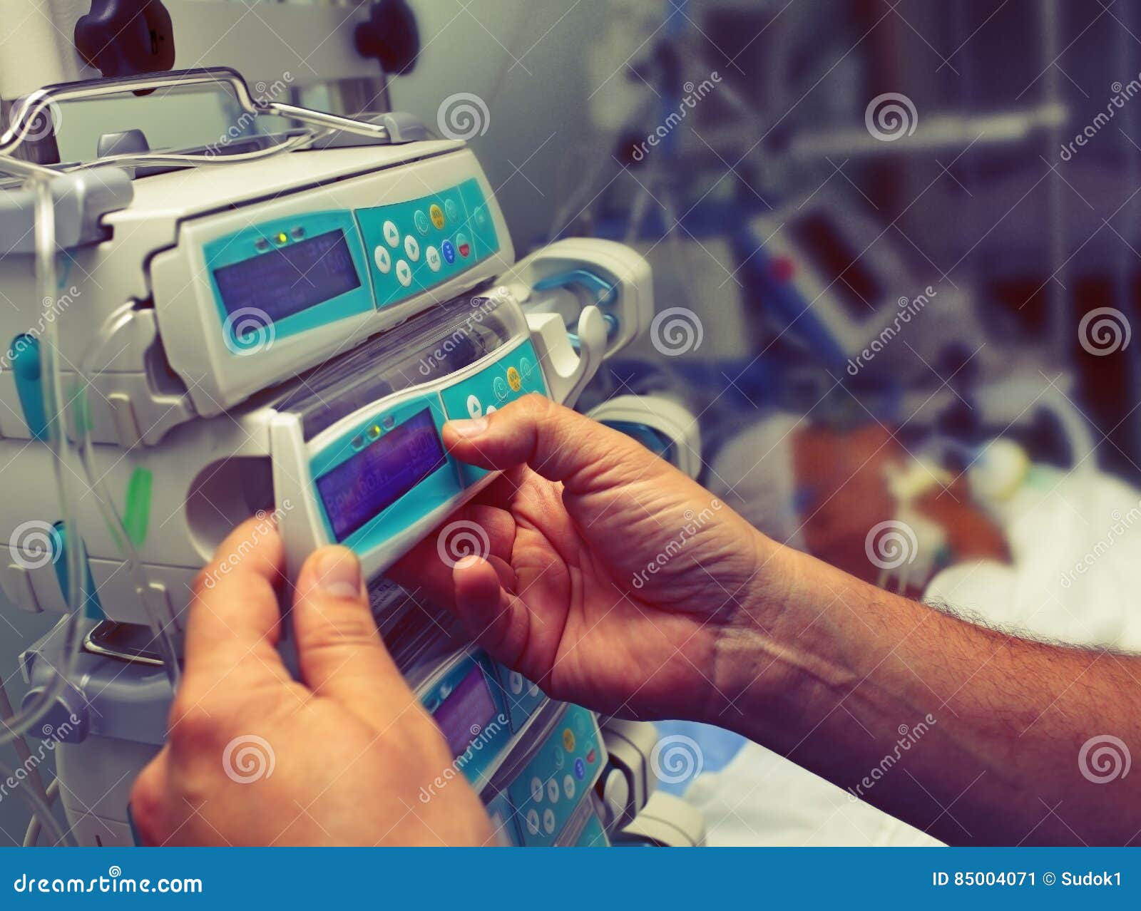medical worker configures equipment in icu