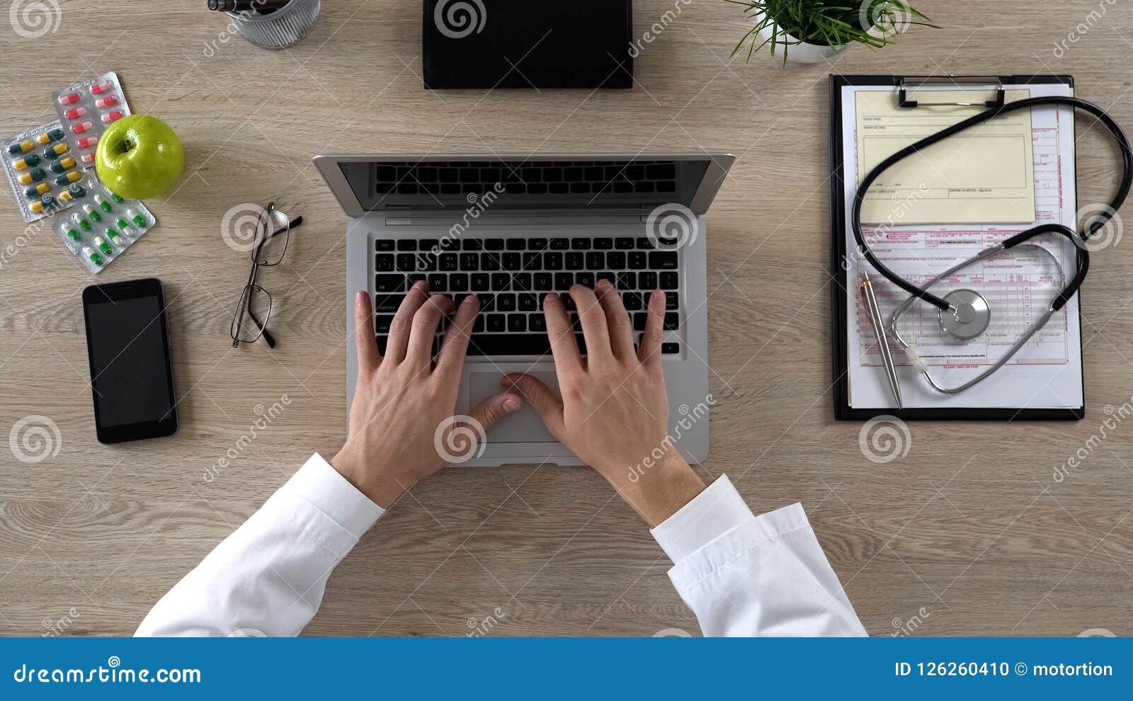 medical worker typing on laptop, keeping electronic medical records, top view