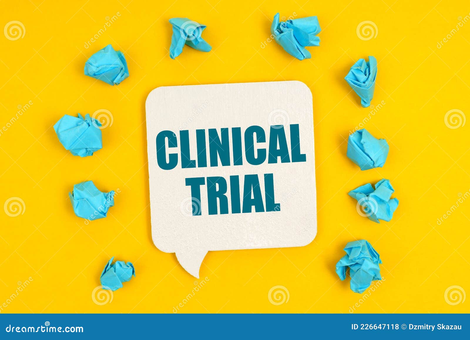 on a yellow background, blue pieces of paper and a sign with the inscription - clinical trial