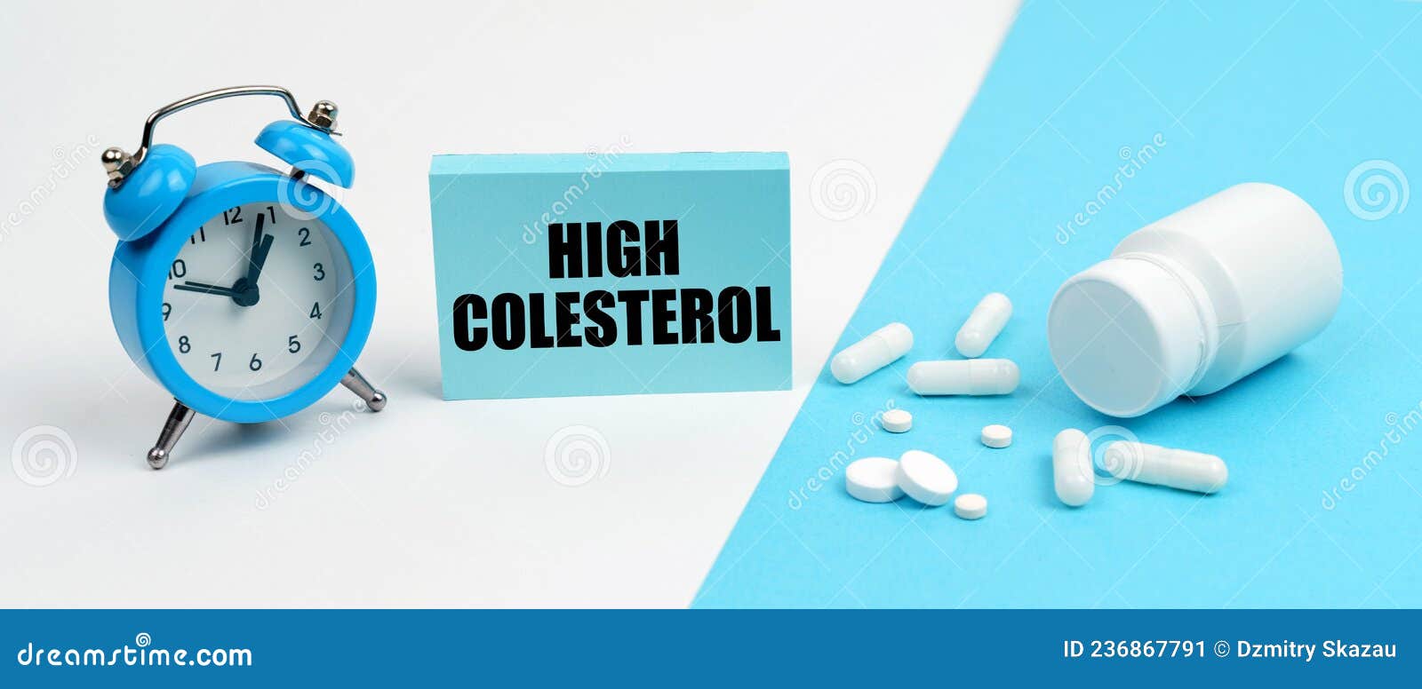 on a blue surface are pills, on a white surface an alarm clock and a plate with the inscription - high colesterol