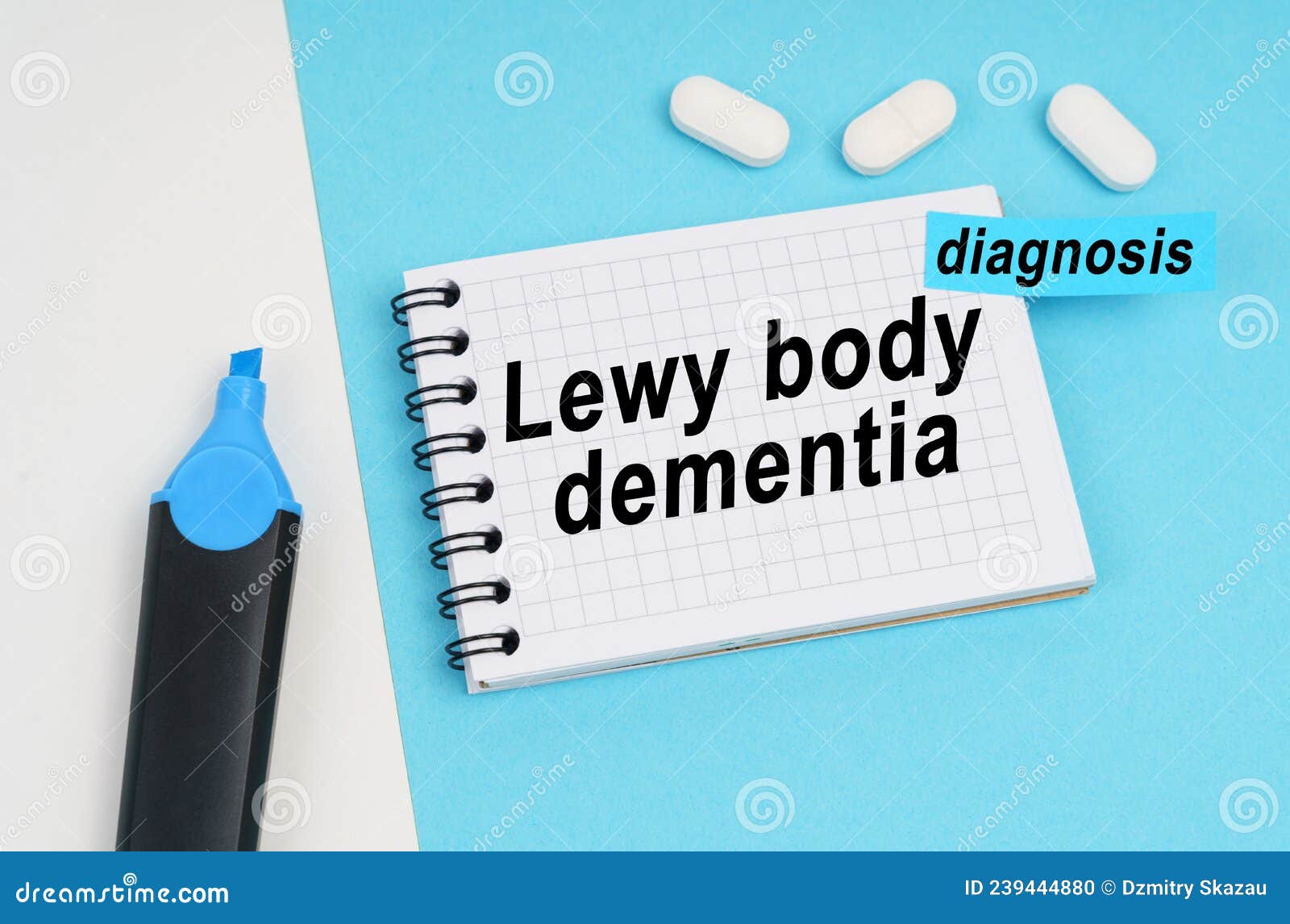 on a white and blue surface are pills, a marker and a notebook with the inscription - lewy body dementia